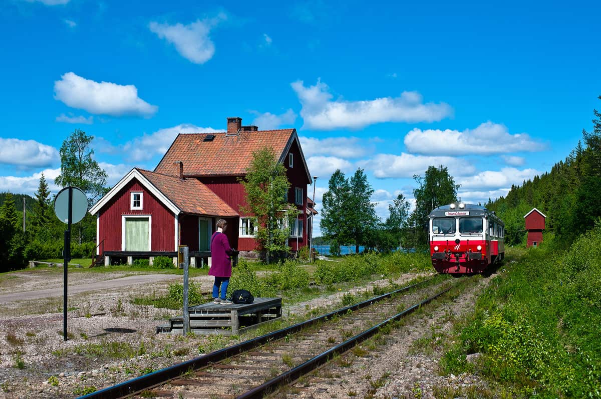 A train approaches Tandsjöborg station to pick up a passenger.
