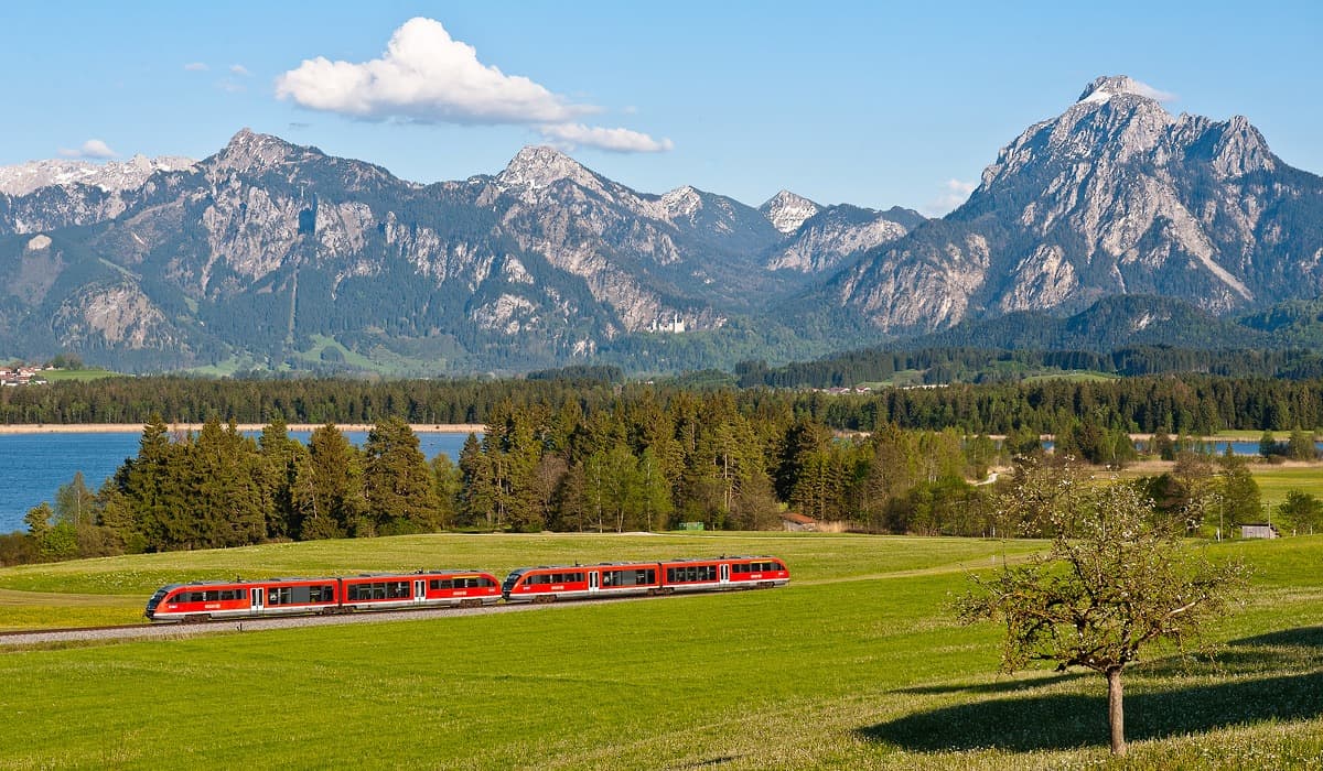 Eine Regionalbahn vor der herrlichen Kulisse von Neuschwanstein und Bayrischen Alpen auf dem Weg nach Füssen.